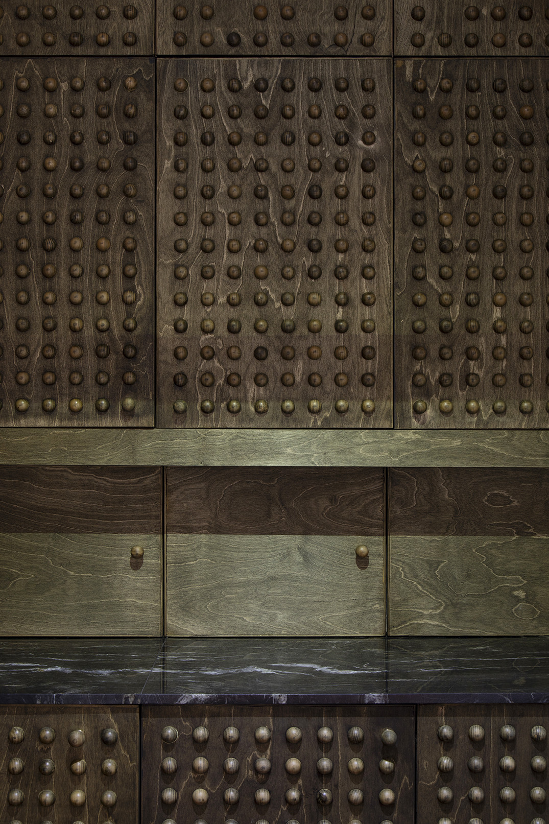 Joinery Detail showing the studs on the joinery - dark wood and granite top